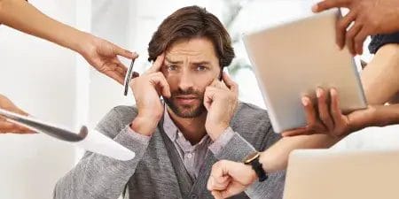 Stressed man covering ears while multiple hands offer phones, documents, and a tablet, symbolizing the need for BitBop support.
