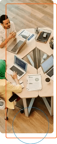 Marketing team collaborating on laptops around a modern triangular table during a strategy session